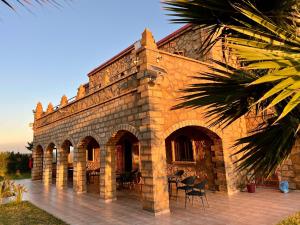 a brick building with tables and chairs on a patio at Villa Sun and Chill, Ferme d'hôtes familiale avec piscine animée, restaurant et jardin près de Safi in Safi