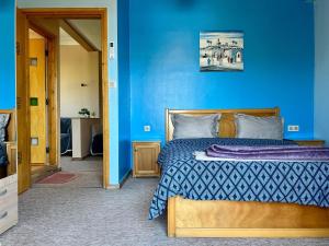 a blue bedroom with a bed and a blue wall at Villa Sun and Chill, Ferme d'hôtes familiale avec piscine animée, restaurant et jardin près de Safi in Safi +107 photos