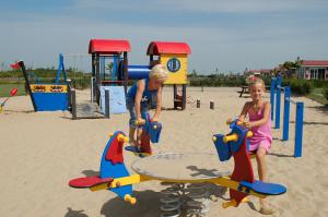 a boy and a girl playing on a playground at Mobilehome Super Mercure 2 Bedrooms Comfort Camping Scheldeoord in Baarland