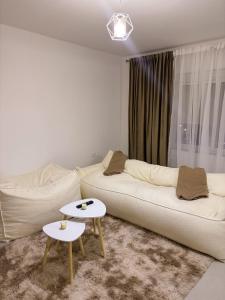 a living room with a white couch and a table at Modern Air Conditioned 2BR in Heart of Shkodër in Shkodër