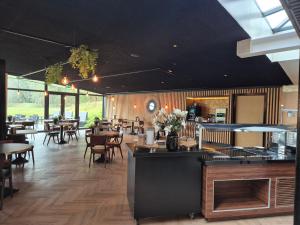 a dining room with tables and chairs and a restaurant at Boshotel Overberg in Overberg