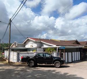 a black truck parked in front of a house at Homestay with pool kuantan in Kuantan