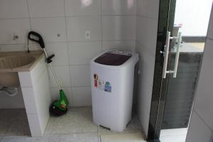 a bathroom with a trash can and a mop at Casa Guarapari - Ferienhaus in Guarapari +58 photos