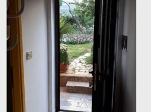 an open door with a view of a stone walkway at Apartment Dijana in Bakar