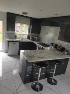 a kitchen with a counter and two bar stools at Garden view Cosy Single Room in Derby +3 photos