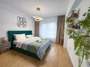 a bedroom with a bed and a potted plant at Mountain and City View with Underground Parking in Braşov +26 photos