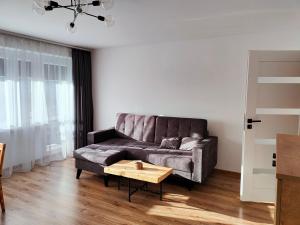 a living room with a couch and a coffee table at Apartament Prudniczanka in Prudnik +3 photos