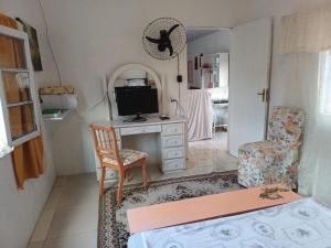 a living room with a television and a chair at Casa do Mato I in São Lourenço do Sul