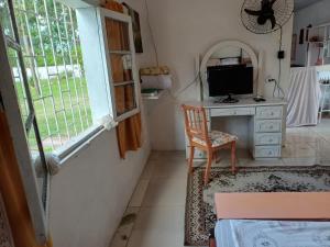 a room with a desk with a computer and a window at Casa do Mato I in São Lourenço do Sul +7 photos