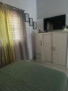a bedroom with a bed and a flat screen tv at RyC La Casita Mirador Del Lago in Villa Parque Siquiman