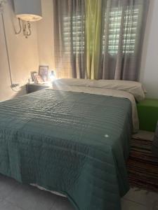 a bedroom with a bed with a green blanket on it at RyC La Casita Mirador Del Lago in Villa Parque Siquiman +6 photos