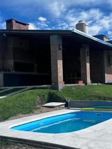 a swimming pool in front of a house at RyC La Casita Mirador Del Lago in Villa Parque Siquiman
