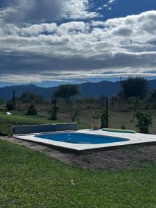 a swimming pool in the middle of a grass field at RyC La Casita Mirador Del Lago in Villa Parque Siquiman