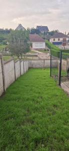 a grassy yard with a fence and a field at Le Millésime in Eu
