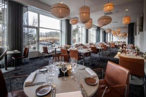 a restaurant with tables and chairs and large windows at Comwell Rebild Bakker in Skorping +24 photos