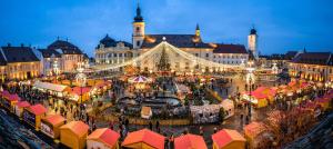 a christmas market in front of a large building at Perfect Residence Sibiu in Sibiu