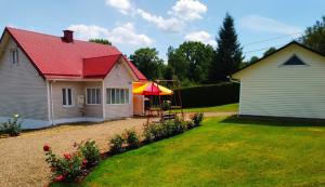 a house with a red roof and a picnic table in the yard at Zielona Żabka in Polańczyk +29 photos