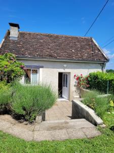 a small white house with flowers in front of it at Gîte Le Four à Pain, 2 chambres, 2km du centre de Dole, in Dole