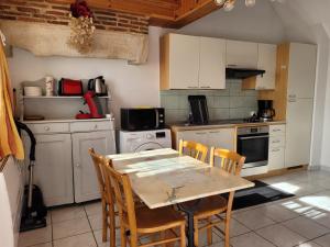 a kitchen with a table and chairs in it at Gîte Le Four à Pain, 2 chambres, 2km du centre de Dole, in Dole