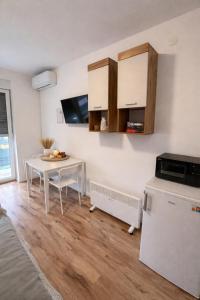 a kitchen with a table and a white refrigerator at Studio apartman ANNI, Self CHECK-IN in Osijek +14 photos