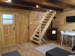 a room with a wooden wall with a ladder in it at Domek letniskowy Marksewo Łoś in Marksoby +5 photos