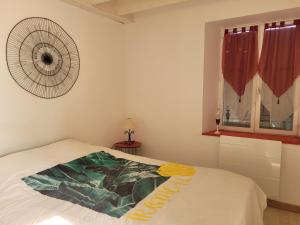 a bedroom with a bed with a fan on the wall at Gîte Le Four à Pain, 2 chambres, 2km du centre de Dole, in Dole
