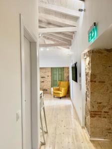 a hallway with a yellow couch in a room at Central Suites Aegina 5 in Egina