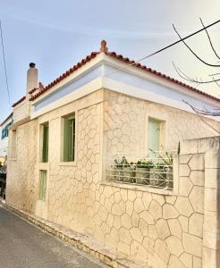 a building with a balcony with plants on it at Central Suites Aegina 5 in Egina
