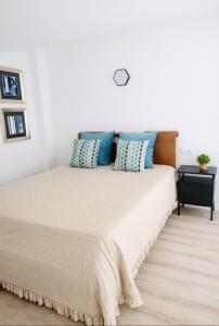 a bedroom with a large bed with blue pillows at Casa luz e conforto-Casa 20 in Almancil
