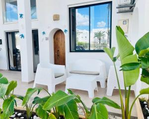 a room with white chairs and a window at Dar Aicha Marina Hammamet Sud in Hammamet
