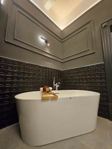 a white bath tub in a bathroom with a ceiling at Portus Noir Valletta in Valletta +28 photos