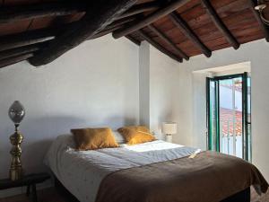 a bedroom with a bed with two pillows and a window at Pisco Charming House - Alter Pedroso in Alter do Chão
