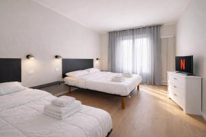a hotel room with two beds and a television at Elisir in Bergamo