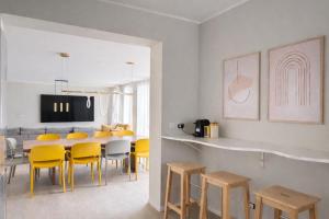 a dining room with a table and yellow chairs at Elisir in Bergamo
