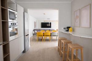 a kitchen and dining room with yellow chairs and a table at Elisir in Bergamo