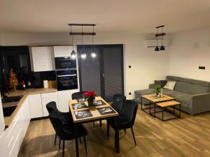 a kitchen and a living room with a table and chairs at Leśna Przystań Kaszuby in JeleÅ„ska Huta