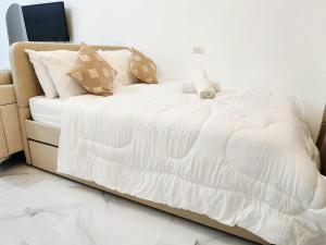 a bed with white sheets and pillows in a room at AJB Royal Ocean Crest Mactan Cebu in Cebu City +13 photos