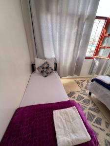 a small bed in a room with a window at Hostel dallas Warzazate in Ouarzazate
