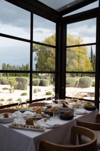a table with plates of food and wine glasses at Hotel Boutique Villa Emilia in Playa