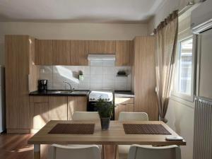 a kitchen with a wooden table and chairs and a kitchen with a sink at Mary's Pool Apartment in Perea