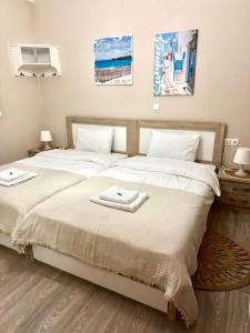 a bedroom with two beds with towels on them at Holiday Dream Artemis Apartment in Mastihari