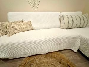 a white couch with pillows on top of it at Holiday Dream Artemis Apartment in Mastihari