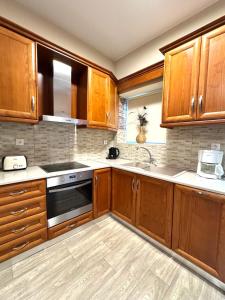 a kitchen with wooden cabinets and a stove top oven at Holiday Dream Artemis Apartment in Mastihari