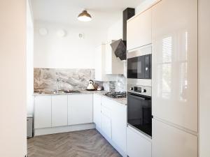 a white kitchen with white cabinets and black appliances at Liquorstane - Uk40568 in Falkland