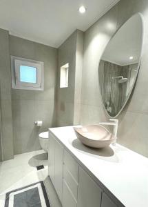 a bathroom with a bowl sink and a mirror at Holiday Dream Artemis Apartment in Mastihari
