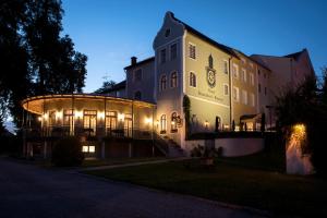 a large building with lights on the side of it at Gutshotel Odelzhausen in Odelzhausen +7 photos