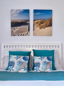 a bed with three pictures of a beach and a pier at Benalbeach Smart Suite in Benalmádena +24 photos