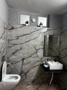 a bathroom with a stone wall with a toilet and a sink at Maison Royale House 3bhk apartment in Jaipur +39 photos