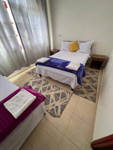 a bedroom with two beds and a rug at Hostel dallas Warzazate in Ouarzazate