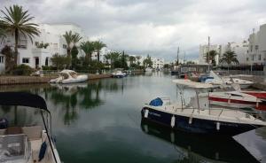 a group of boats docked in a river with buildings at Dar Aicha Marina Hammamet Sud in Hammamet